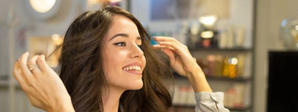 Happy young woman getting new hairstyle in the professional hair salon. - DASHE Beauty Kuwait